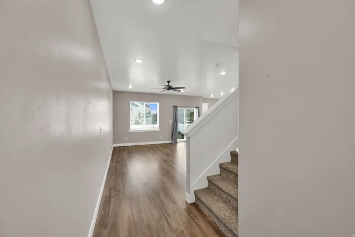 Open-concept living space with wood-finish flooring, recessed lighting, and a ceiling fan