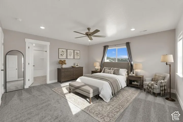 Recessed lighting, ceiling fan, carpet flooring, large window, and an en-suite bathroom featuring a tub/shower combination