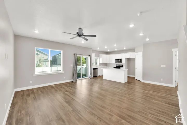Open-concept living area featuring wood-finish flooring, recessed lighting, and a ceiling fan