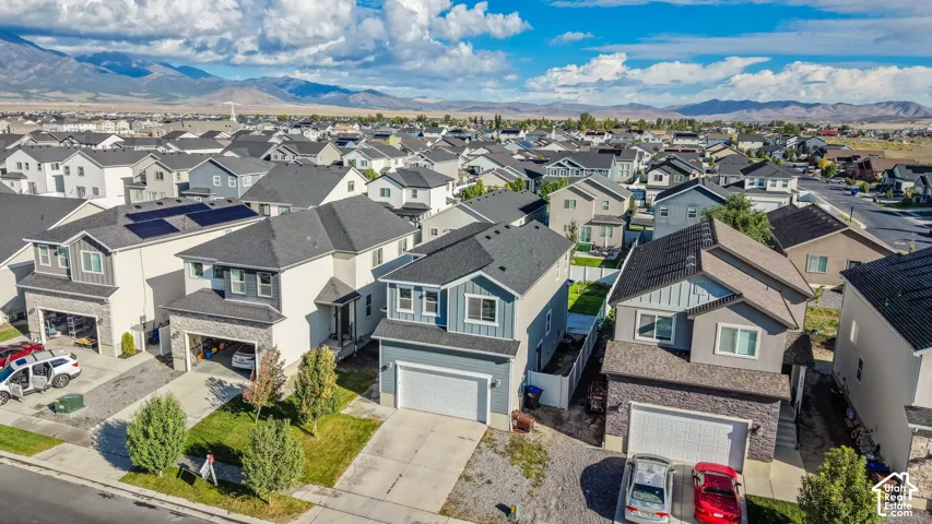 Modern residential architecture with pitched roofs, integrated garages, and varied exterior finishes