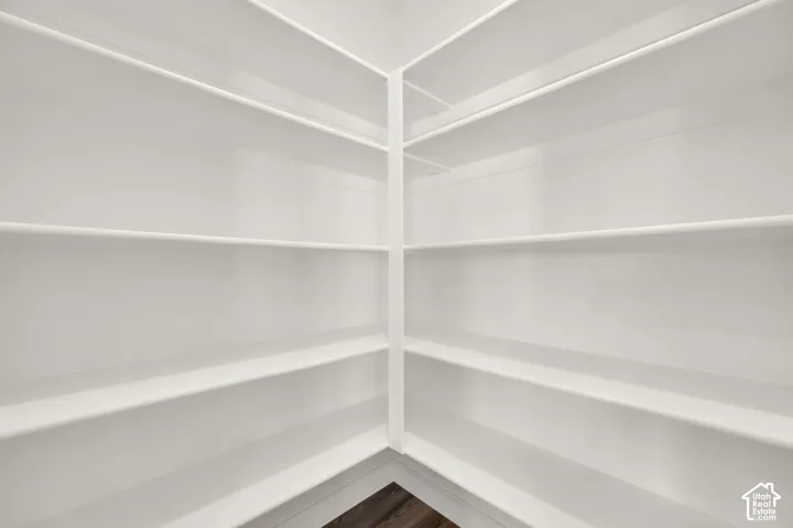 Built-in white shelving system with a corner configuration, offering extensive storage capacity