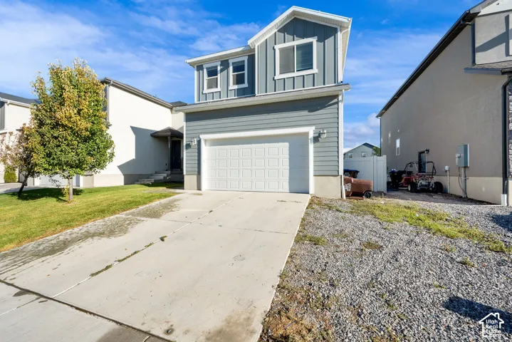 Two-story residence featuring light gray siding, white trim, and an attached two-car garage