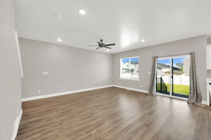 Spacious room with wood-finish flooring, recessed lighting, and a ceiling fan
