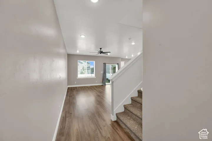Open-concept living space with wood-finish flooring, recessed lighting, and a ceiling fan