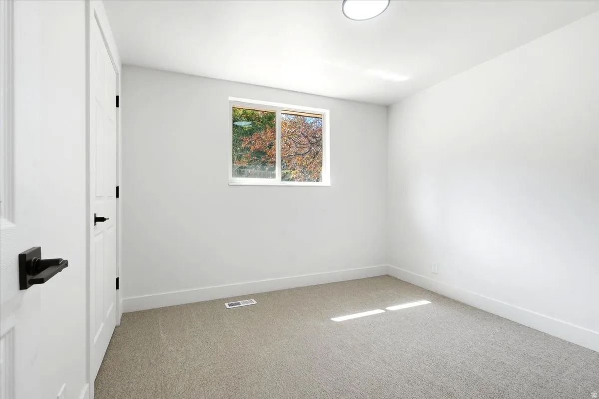 Neutral wall finishes, recessed lighting, white trim, and a window for natural light
