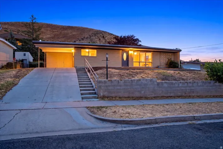 Ranch-style exterior with brick siding, a covered carport, and a concrete driveway