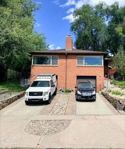 Brick exterior with multiple garages and a prominent brick chimney