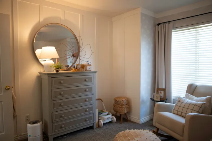 Board and batten accent wall, window with blinds and drapes, wall-to-wall carpeting, crown molding