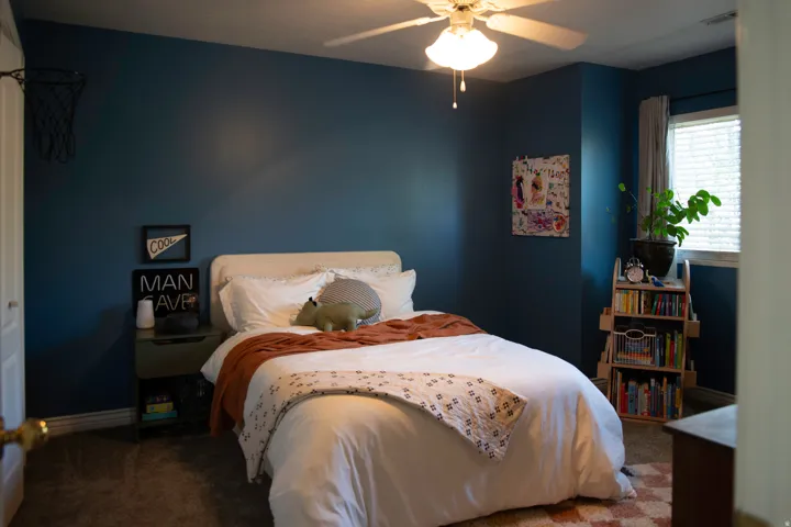 Window with blinds, ceiling fan, and dark-toned wall paint