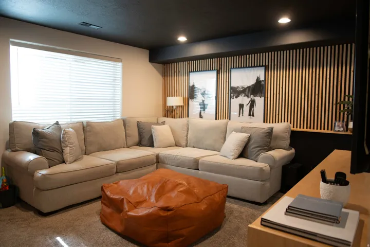 Recessed lighting illuminates a feature wall with vertical wood paneling and a built-in display ledge