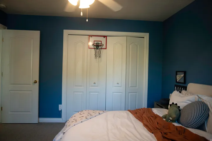 Carpeted flooring, a white interior door, and a bi-fold closet door