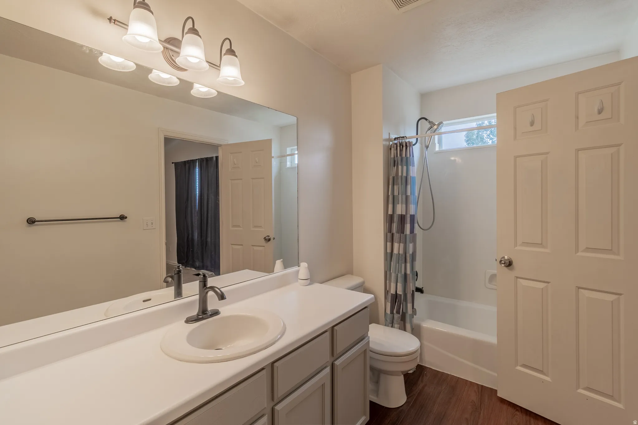 Bathroom featuring a single vanity with an integrated sink, dark bronze-finish faucet, and overhead vanity lighting