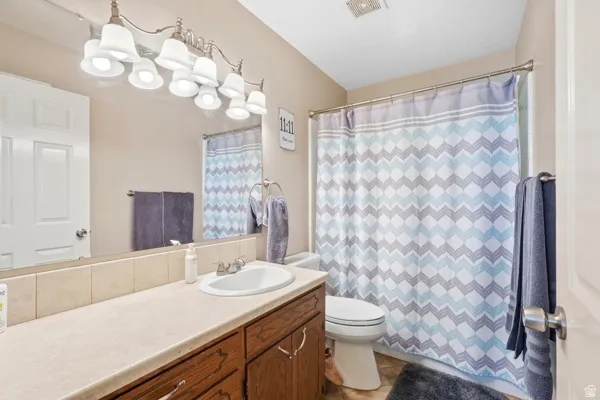 Vanity with integrated sink, wood-finish cabinetry, and a full-width mirror