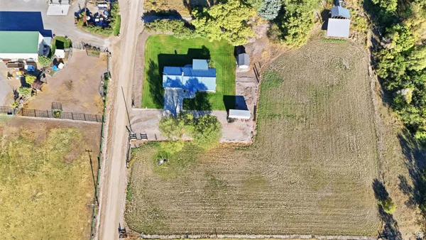 Property featuring a detached structure, gravel driveway, and a large cultivated area