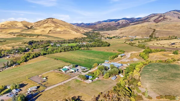 Expansive land offering diverse terrain including flat fields, mountainous backdrops, and established structures