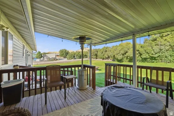 Covered deck with wood-finish flooring, wood railing, and string lighting