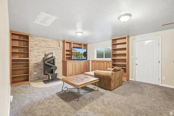 Built-in cabinetry with wood-finish shelving, brick accent wall, and a fixed window