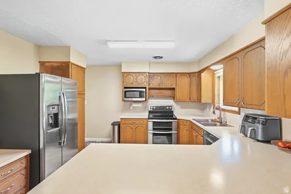 Spacious kitchen featuring wood cabinetry, stainless steel appliances, and ample counter space