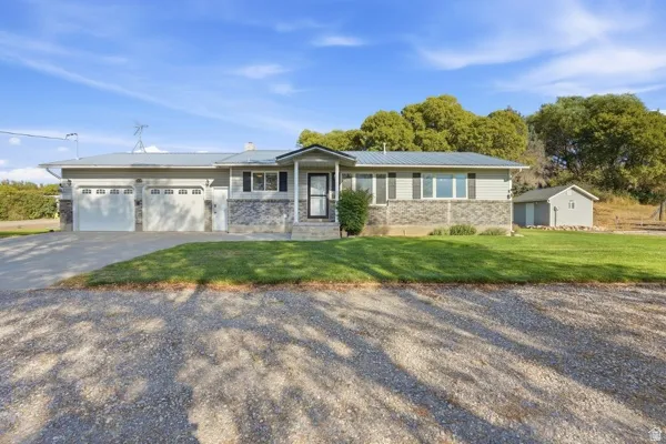 Ranch-style exterior with stone and siding facade, covered front porch, and an attached two-car garage