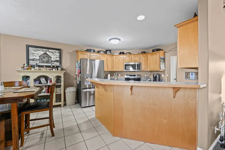 Kitchen featuring wood cabinetry, stainless steel appliances, and a breakfast bar with an integrated countertop