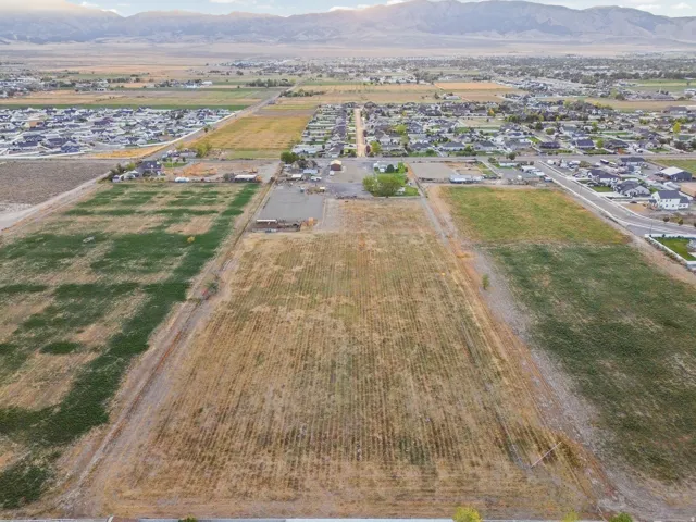 Expansive land parcel with surrounding residential areas and distant mountain scenery