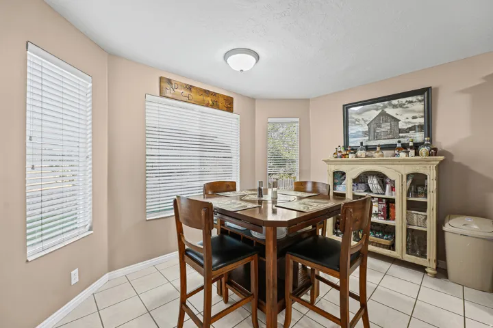 Recessed lighting illuminates the space, featuring multiple windows and tiled flooring