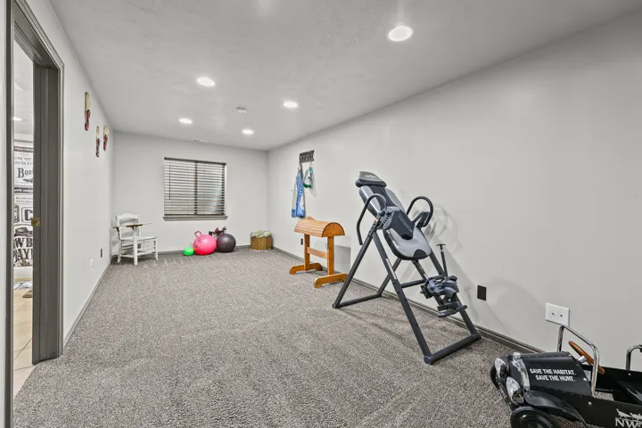 Carpeted room with recessed lighting and a window featuring horizontal blinds