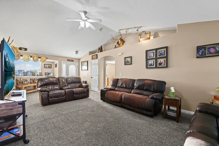 Vaulted ceiling with a ceiling fan, recessed lighting, and wall-to-wall carpeting