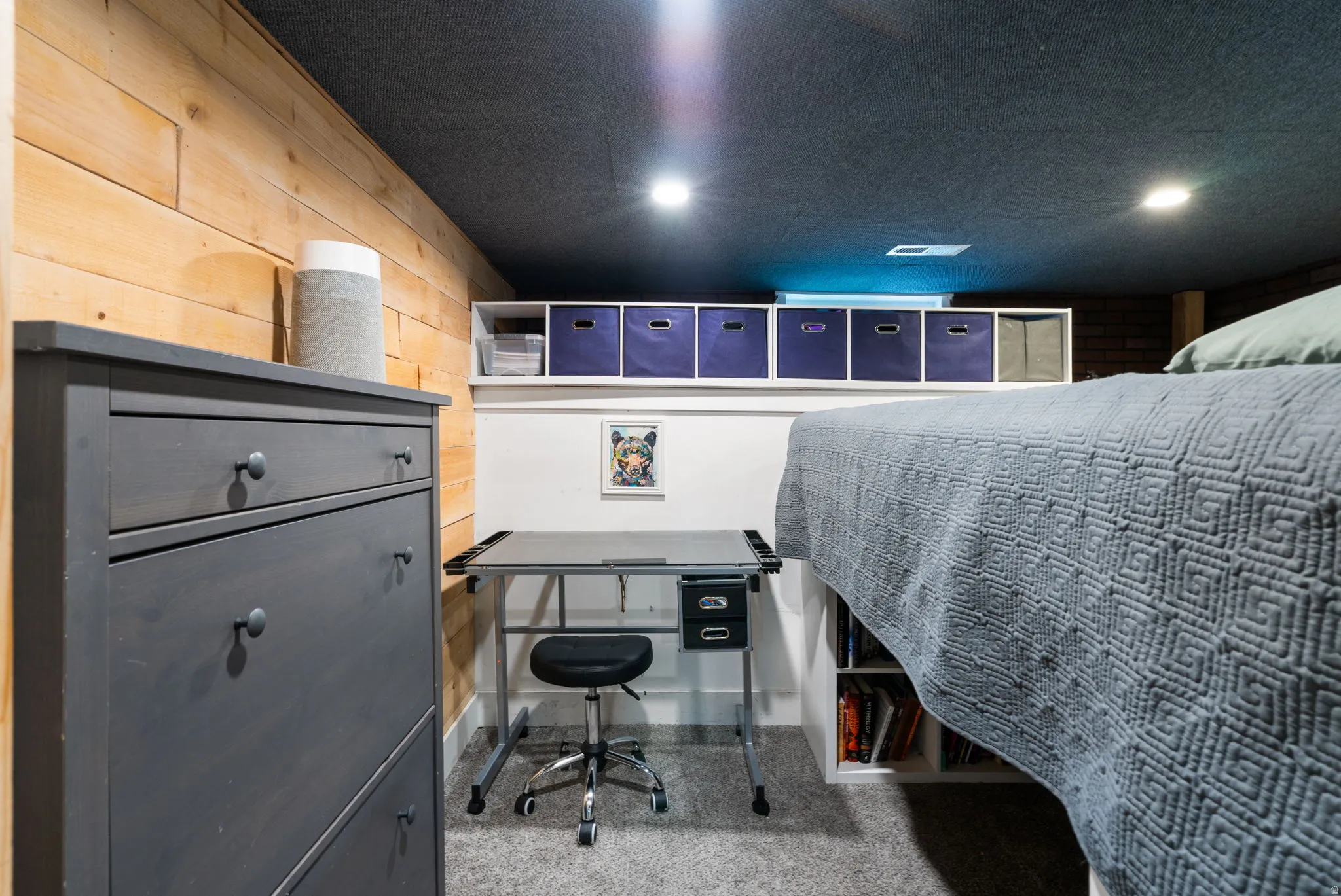 Wood-paneled wall accent, recessed lighting, built-in shelving, carpeted flooring, and a built-in platform bed frame