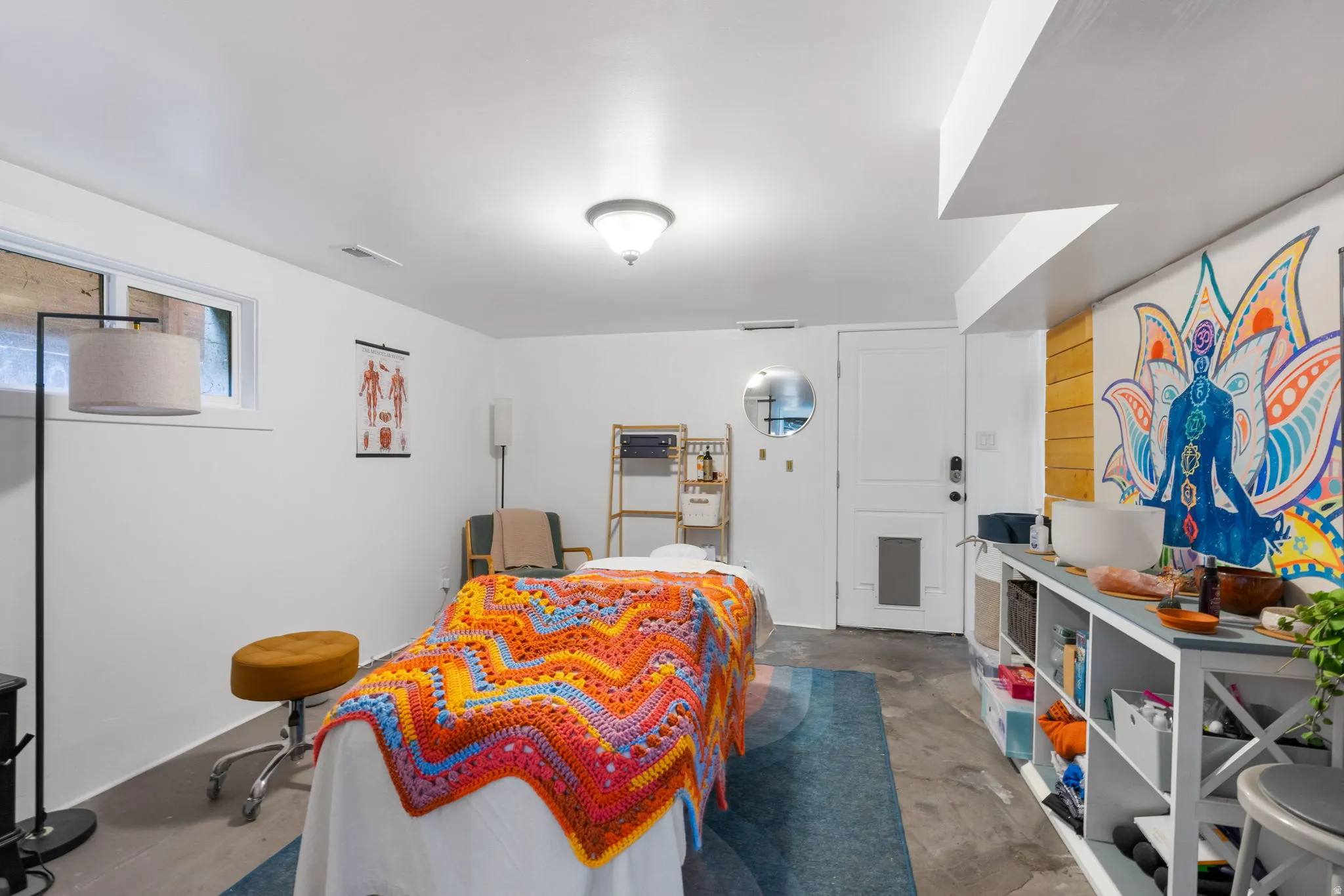 Recessed window with white trim, concrete flooring, built-in shelving, white paneled door, and ceiling-mounted light fixture