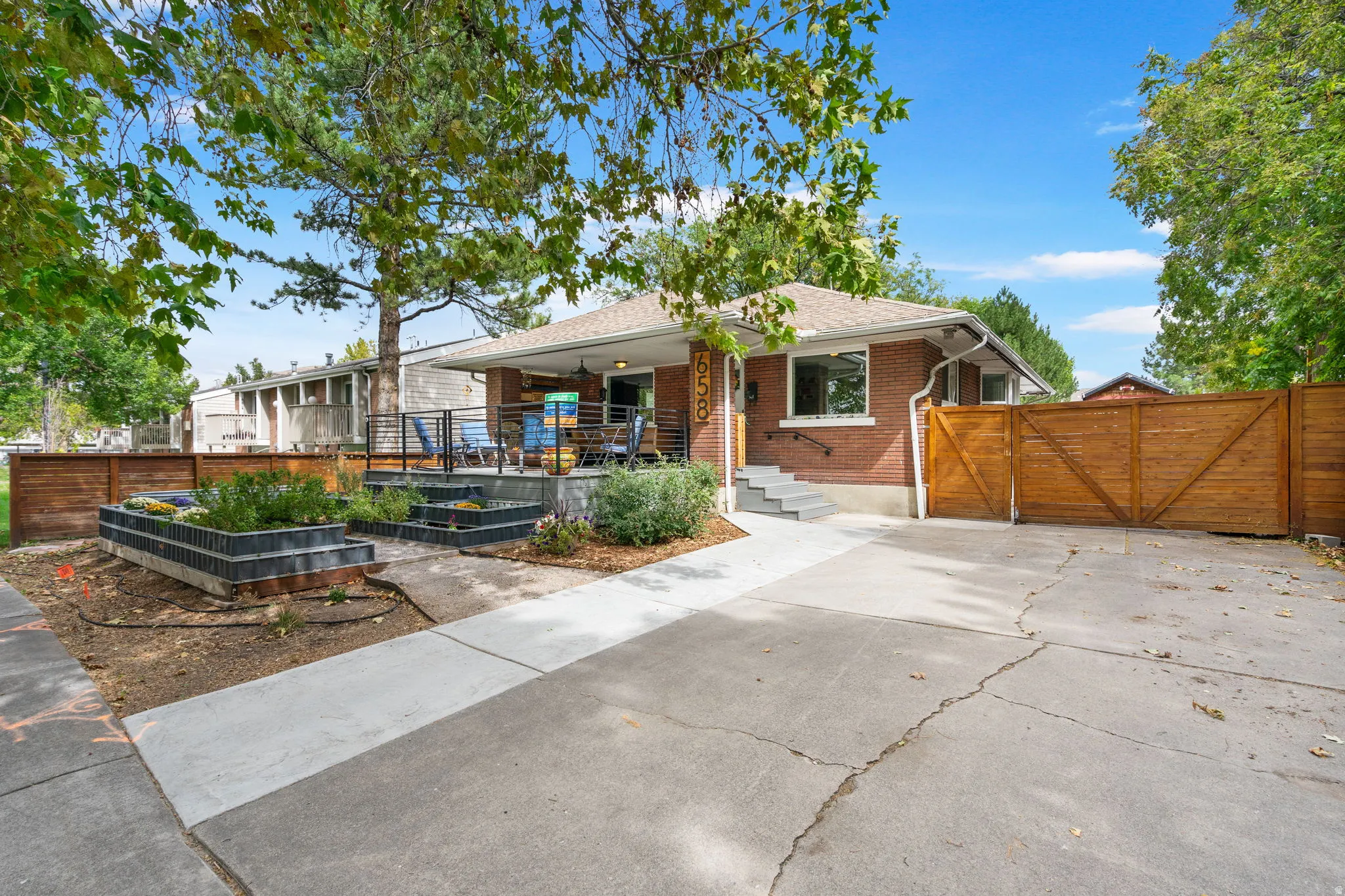 Brick exterior with a gabled roof, a raised front porch with contemporary railings, and concrete steps