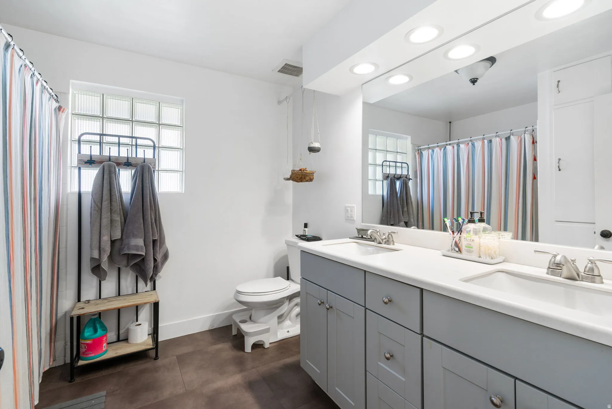Dual basin vanity with light gray cabinetry and white countertop, featuring brushed nickel fixtures