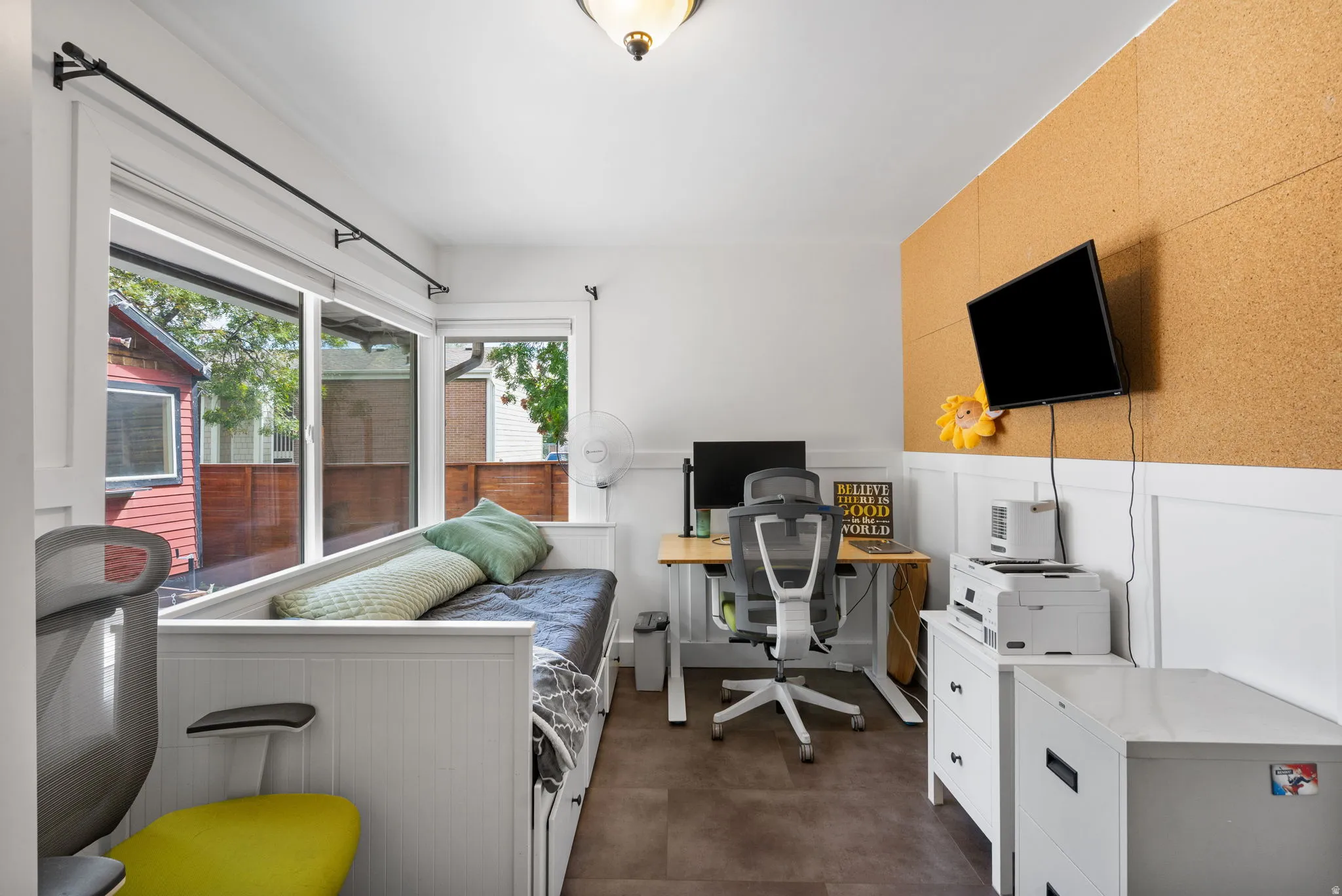 Large windows, wainscoting, cork wall paneling, and wood-finish flooring