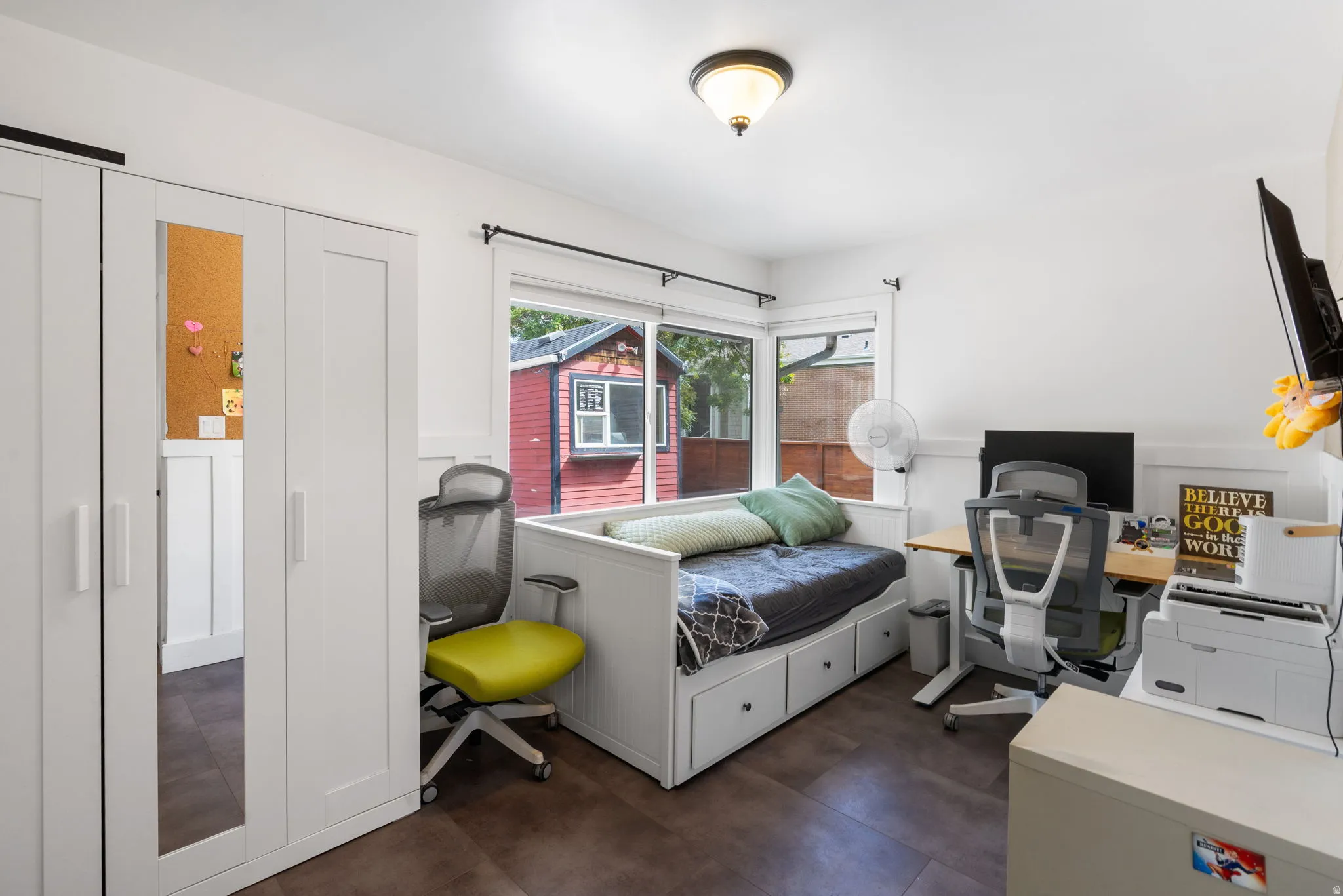 White built-in storage solutions with mirrored door panels, wood-finish flooring, and a large window with a white frame