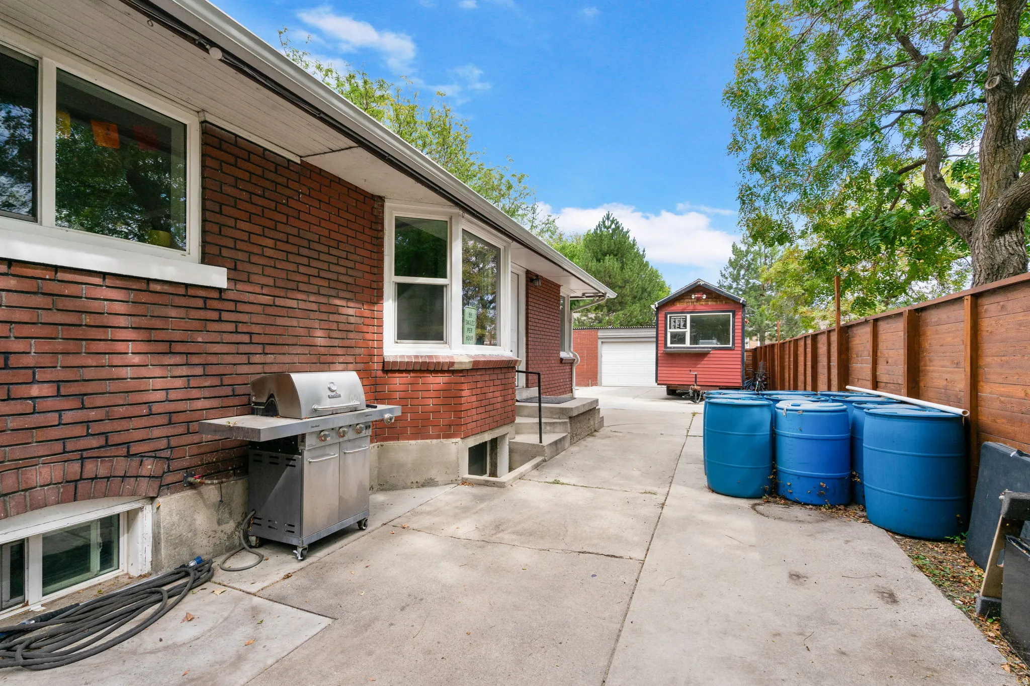 Red brick exterior with white trim windows and concrete patio