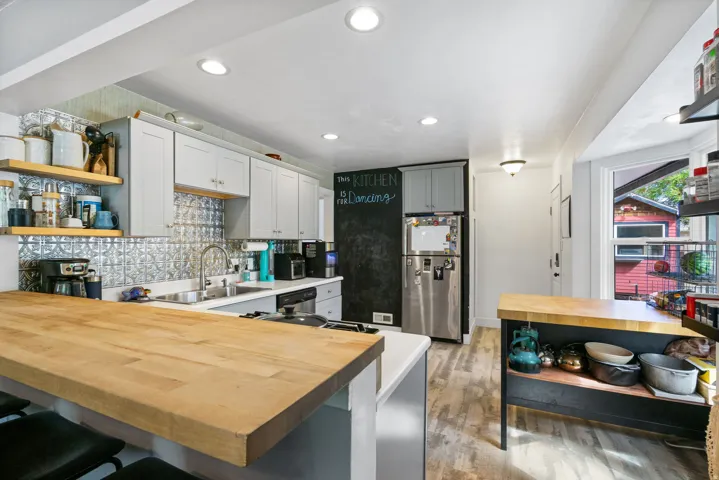 Kitchen featuring light wood-finish flooring, recessed lighting, light gray cabinetry, a tile backsplash, and a butcher block countertop