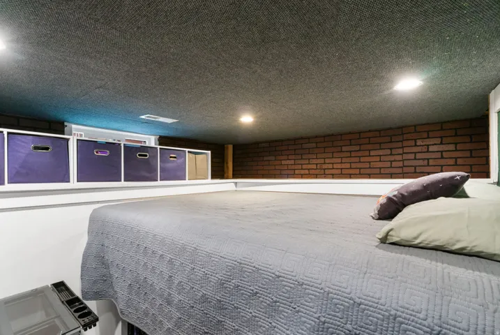 Exposed brick wall detail, recessed lighting, and built-in shelving