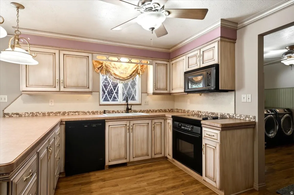 Kitchen featuring wood-finish flooring, light-toned cabinetry, built-in black appliances, and a ceiling fan with integrated lighting