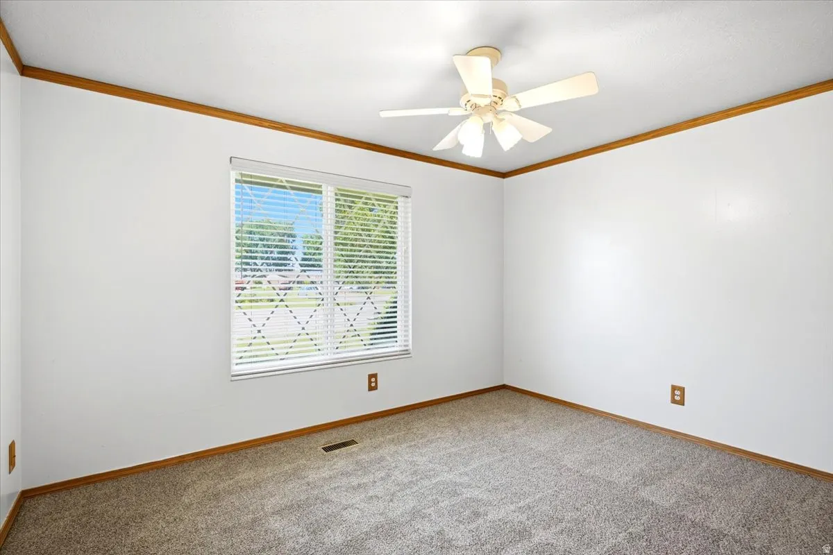 Neutral white walls, wood-finish trim, and a ceiling fan