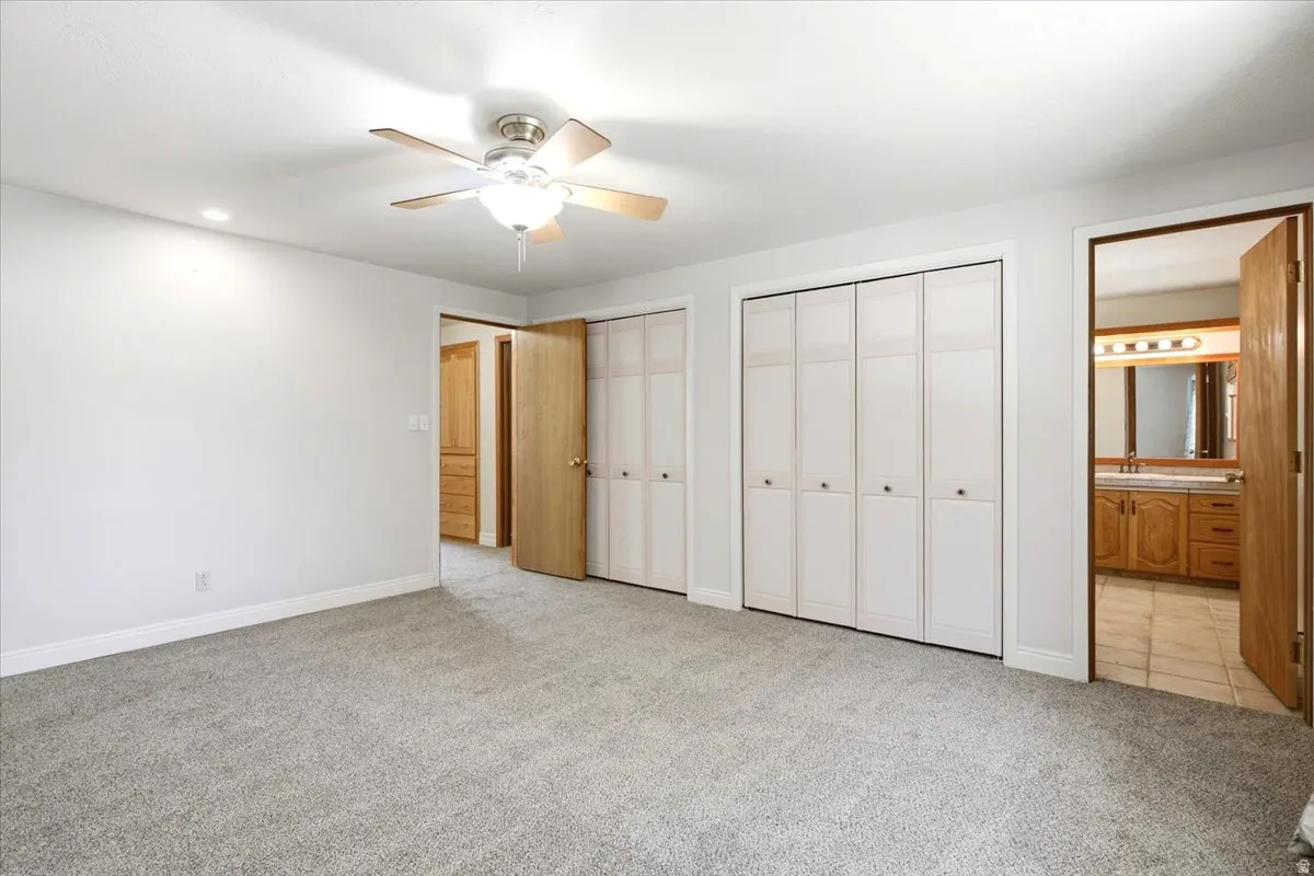 Recessed ceiling lighting, ceiling fan with light fixture, light gray carpeting, and bi-fold closet doors