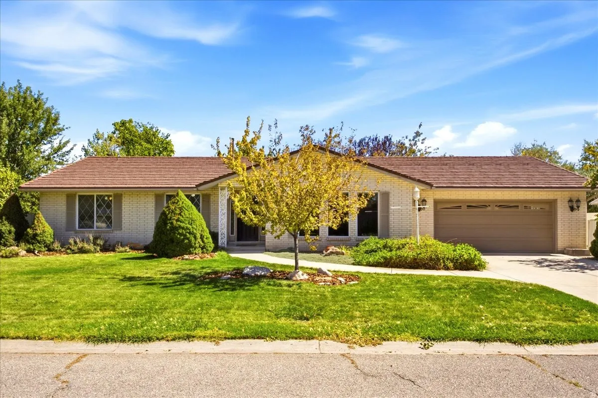 Brick exterior with a brown shingle roof, attached two-car garage, and a concrete driveway