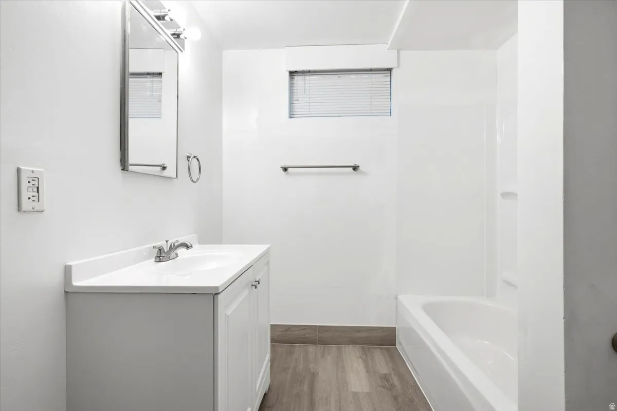 White vanity with integrated sink, chrome faucet, and white countertop