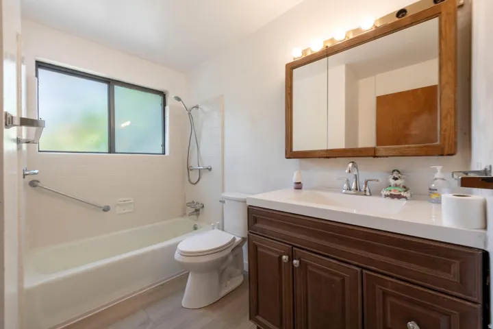 Bathroom featuring a vanity with dark wood-finish cabinetry, a white countertop, and an integrated sink