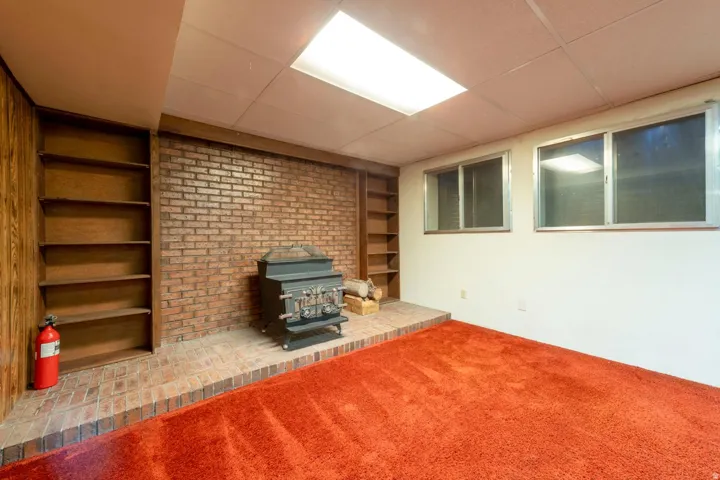 Brick accent wall with a wood-burning stove and a raised hearth