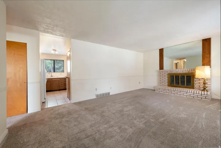 Living area with a white brick fireplace and a large mirror surround