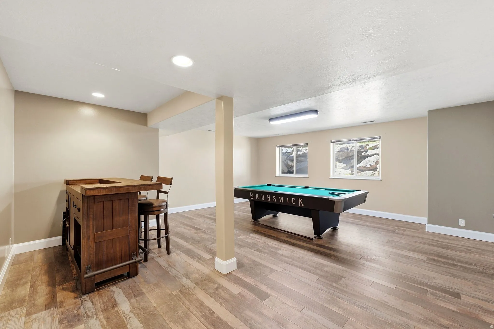 Spacious room with wood-finish flooring, recessed lighting, and two windows