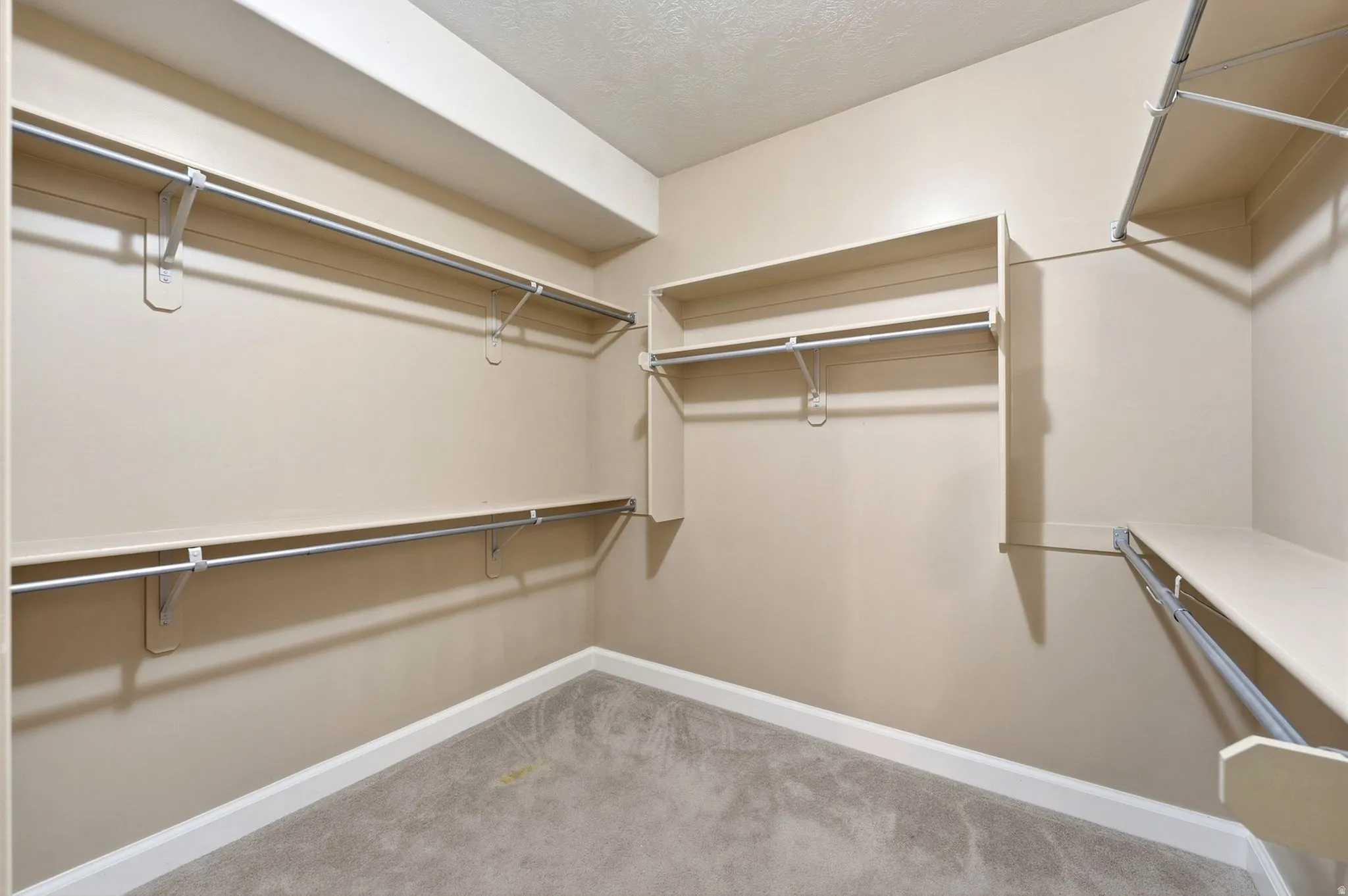 Neutral-toned walls with multiple shelving units and hanging rods