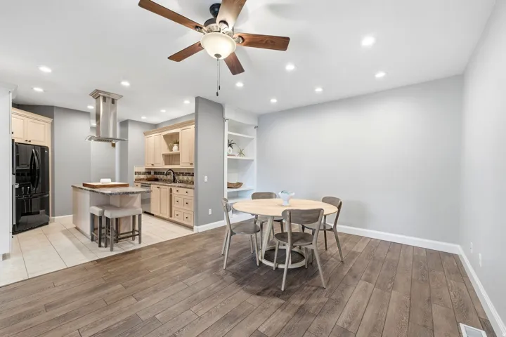 Hardwood-style flooring in main living area, recessed lighting, ceiling fan, and built-in shelving