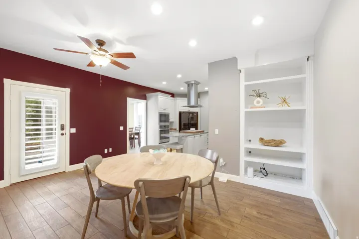 Wood-finish flooring, recessed lighting, ceiling fan, and built-in shelving