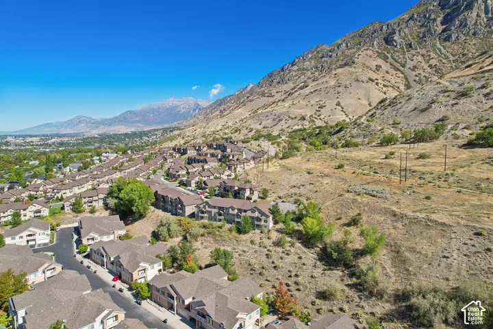 Mountainous terrain bordering a residential area with a clear sky